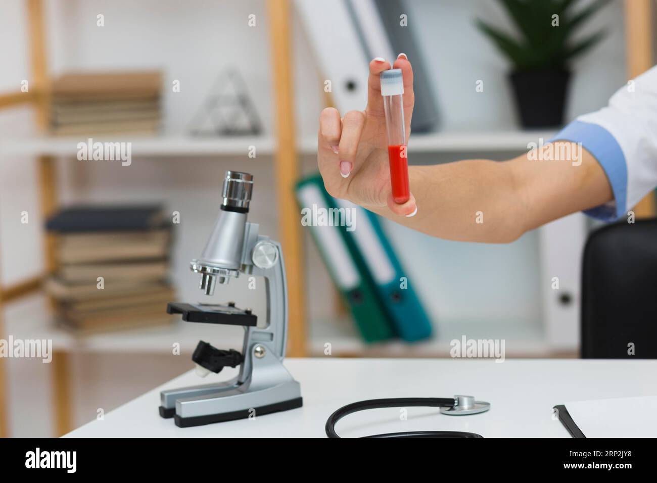 Mano medica femminile che tiene il campione di sangue Foto Stock