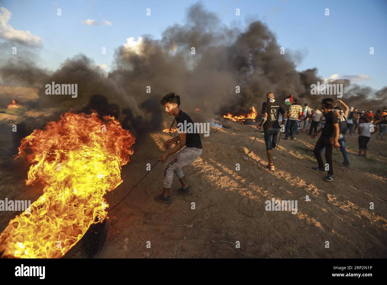 (180907) -- GAZA, 7 settembre 2018 -- Un manifestante palestinese brucia le gomme durante gli scontri con le truppe israeliane sul confine tra Gaza e Israele, a est della città di Gaza, il 7 settembre 2018. Centinaia di palestinesi si sono Uniti venerdì alle manifestazioni anti-Israele, note come la grande marcia del ritorno, vicino al confine con Israele. ) MIDEAST-GAZA-CLASH WissamxNassar PUBLICATIONxNOTxINxCHN Foto Stock