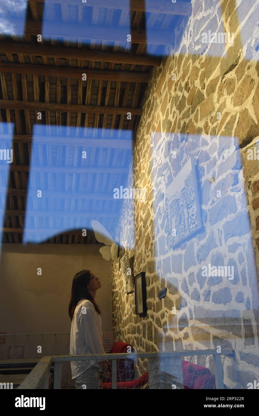 (180917) -- PINGTAN, 17 settembre 2018 -- Lin i Chen, un taiwanese, guarda il quadro a tema lapideo nella zona artistica Rocks CAN Sing nel villaggio di Beigang della contea di Pingtan, provincia del Fujian della Cina sud-orientale, 6 settembre 2018. Quando i turisti si avvicinano a Rocks CAN Sing, possono vedere artisti che suonano musica con le rocce e persone sorseggiano un caffè nelle case di roccia. Rocks CAN Sing è un progetto d'arte che comprende alloggi, musica dal vivo, ristorante, caffetteria e negozio di souvenir. Ora, un totale di 10 giovani dalla terraferma e da Taiwan, tra cui il taiwanese Lin i Chen e il suo ragazzo Liao che Wei, lavorano per la Foto Stock