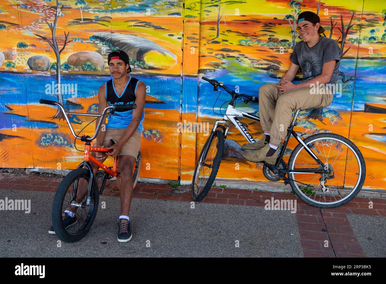 Adolescenti con biciclette contro murales nella città di campagna del Queensland Foto Stock