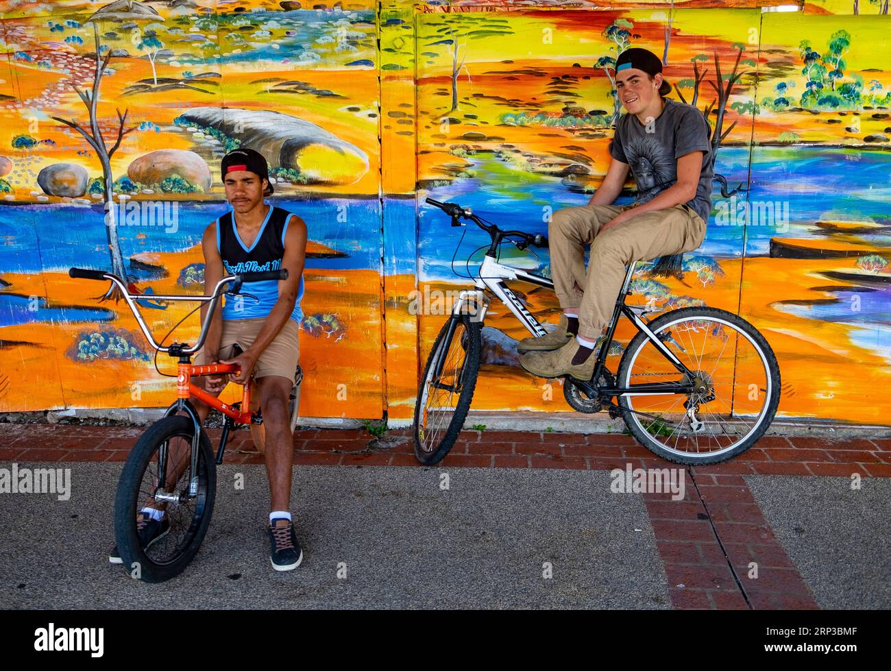 Adolescenti con biciclette contro murales nella città di campagna del Queensland Foto Stock