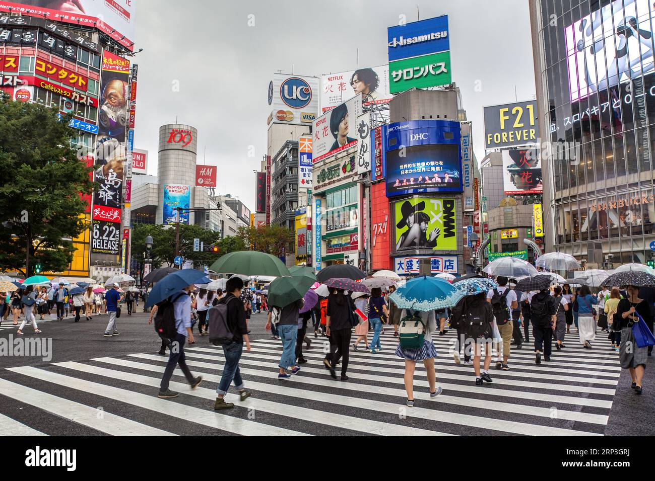 Tokyo, Giappone - 21 giugno 2023: I pedoni sotto la pioggia allo Shibuya Crossing, conosciuto come The Scramble, l'attraversamento pedonale più trafficato del mondo. Foto Stock