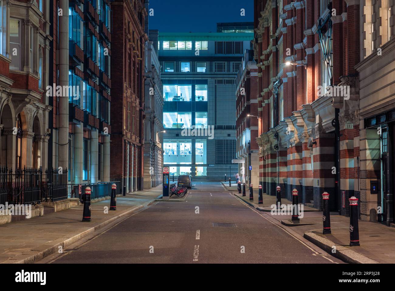 Si tratta di una vista notturna della città di una strada vuota nel quartiere finanziario della City of London il 24 marzo 2022 a Londra, Regno Unito Foto Stock