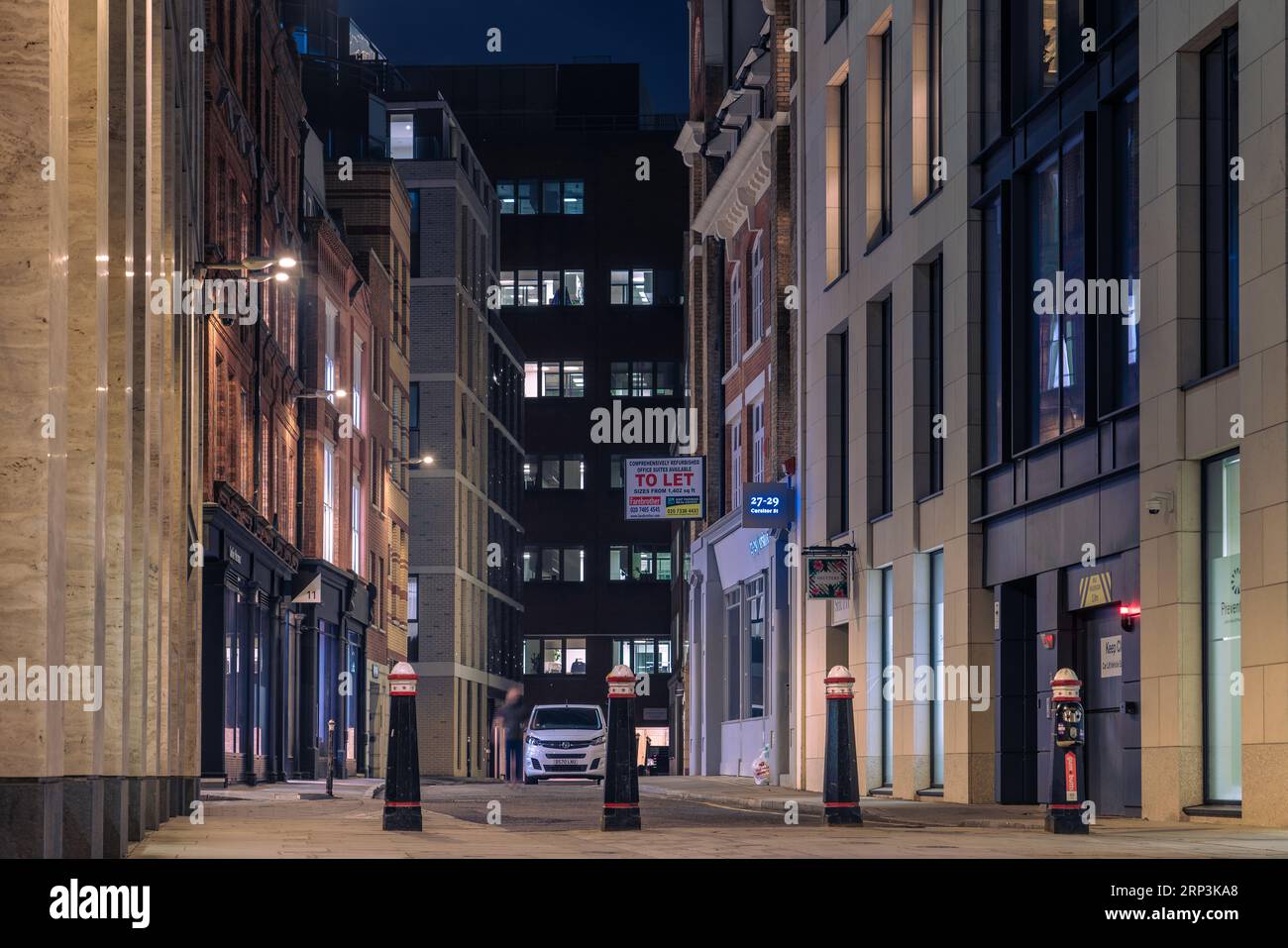 Questa è una vista notturna di una strada nel quartiere finanziario della City of London vicino alla Bank of England il 24 marzo 2022 a Londra, Regno Unito Foto Stock
