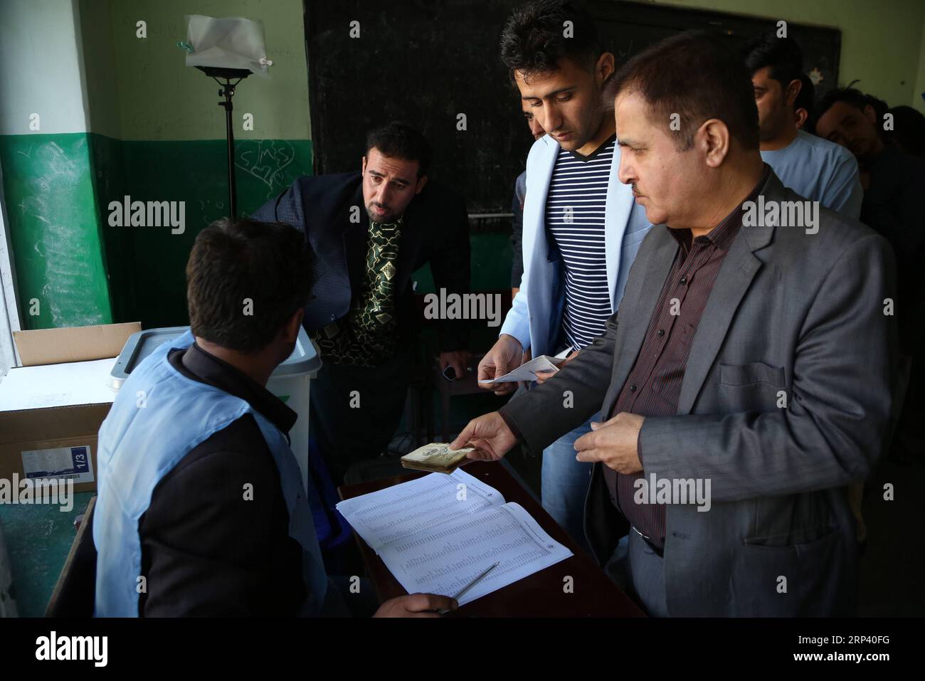 (181020) -- KABUL, 20 ottobre 2018 -- un lavoratore della Commissione elettorale indipendente afghana (IEC) registra un elettore in un collegio elettorale durante le elezioni parlamentari a Kabul, Afghanistan, il 20 ottobre 2018. Milioni di elettori afghani hanno votato sabato per le elezioni parlamentari a lungo ritardate nel paese afflitto dalla militanza, tra notizie di minacce e irregolarità alla sicurezza. ) AFGHANISTAN-KABUL-ELEZIONI PARLAMENTARI RahmatxAlizadah PUBLICATIONxNOTxINxCHN Foto Stock