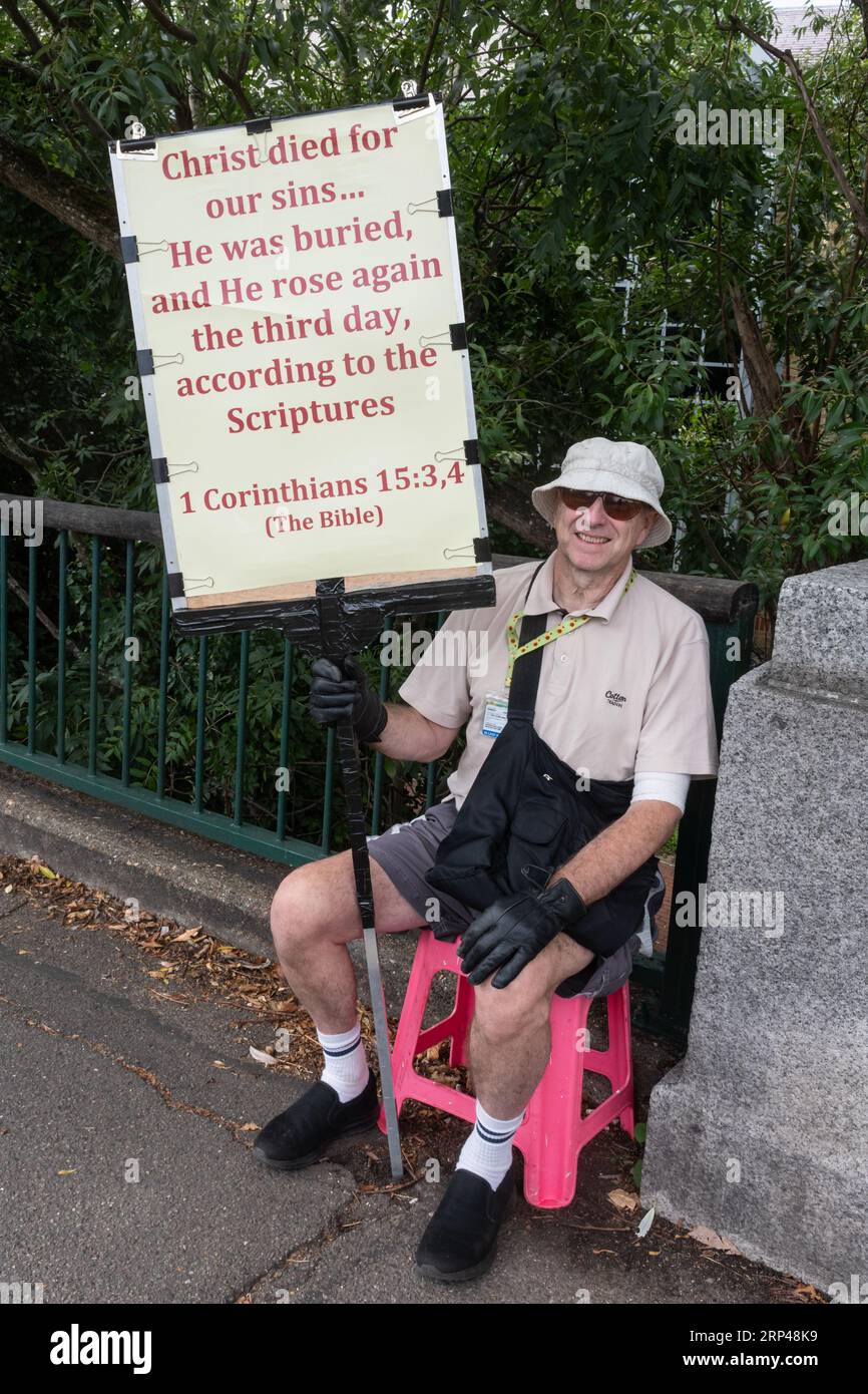 Uomo che tiene un cartello con un messaggio cristiano, membro evangelista della chiesa che comunica le sue convinzioni religiose alle persone per strada, Inghilterra, Regno Unito Foto Stock