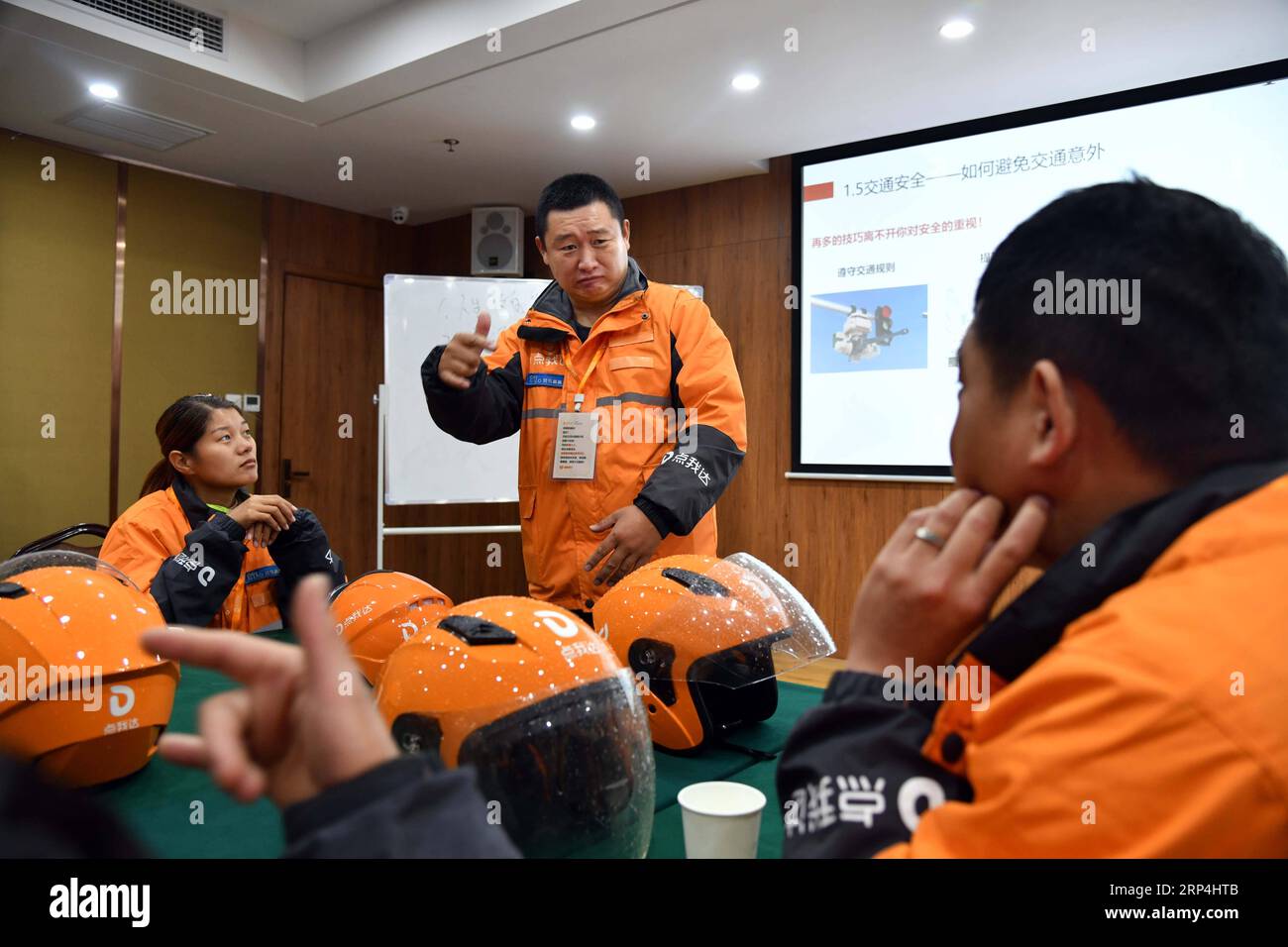 (181109) - JINAN, 9 novembre 2018 - Yang Pengpeng (2nd R) offre un corso di formazione ai colleghi che usano il linguaggio dei segni nel distretto di Kuiwen di Weifang, provincia dello Shandong della Cina orientale, 9 novembre 2018. Un fornitore esterno di servizi di consegna istantanea a Weifang è riuscito ad assumere più di 30 ciclisti con problemi di udito che, dopo una formazione professionale pertinente, si stanno dimostrando altrettanto competenti come i loro coetanei senza perdita dell'udito. Il team di consegna per non udenti dell'azienda è composto da piloti di diversa provenienza: Laureato, madre single, ex guida Foto Stock