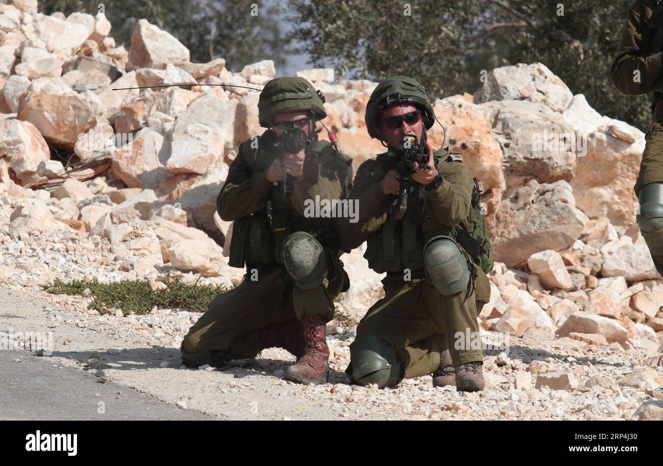 (181109) -- NABLUS, 9 novembre 2018 -- soldato israeliano mirare le proprie armi contro i manifestanti palestinesi durante gli scontri dopo una protesta contro l'espansione degli insediamenti ebraici nel villaggio di Kufr Qadoom vicino alla città di Nablus, in Cisgiordania, il 9 novembre 2018. ) (Djj) MIDEAST-NABLUS-CLASHES NidalxEshtayeh PUBLICATIONxNOTxINxCHN Foto Stock