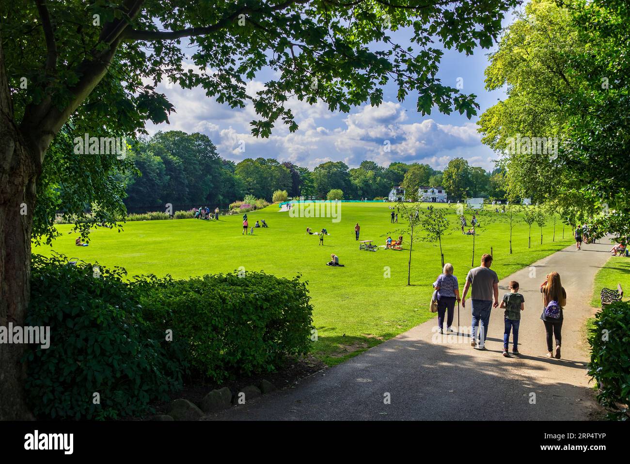 Un pomeriggio pigro e soleggiato al Roberts Park di Saltaire sulle rive del fiume Aire con una partita di cricket in corso. Foto Stock