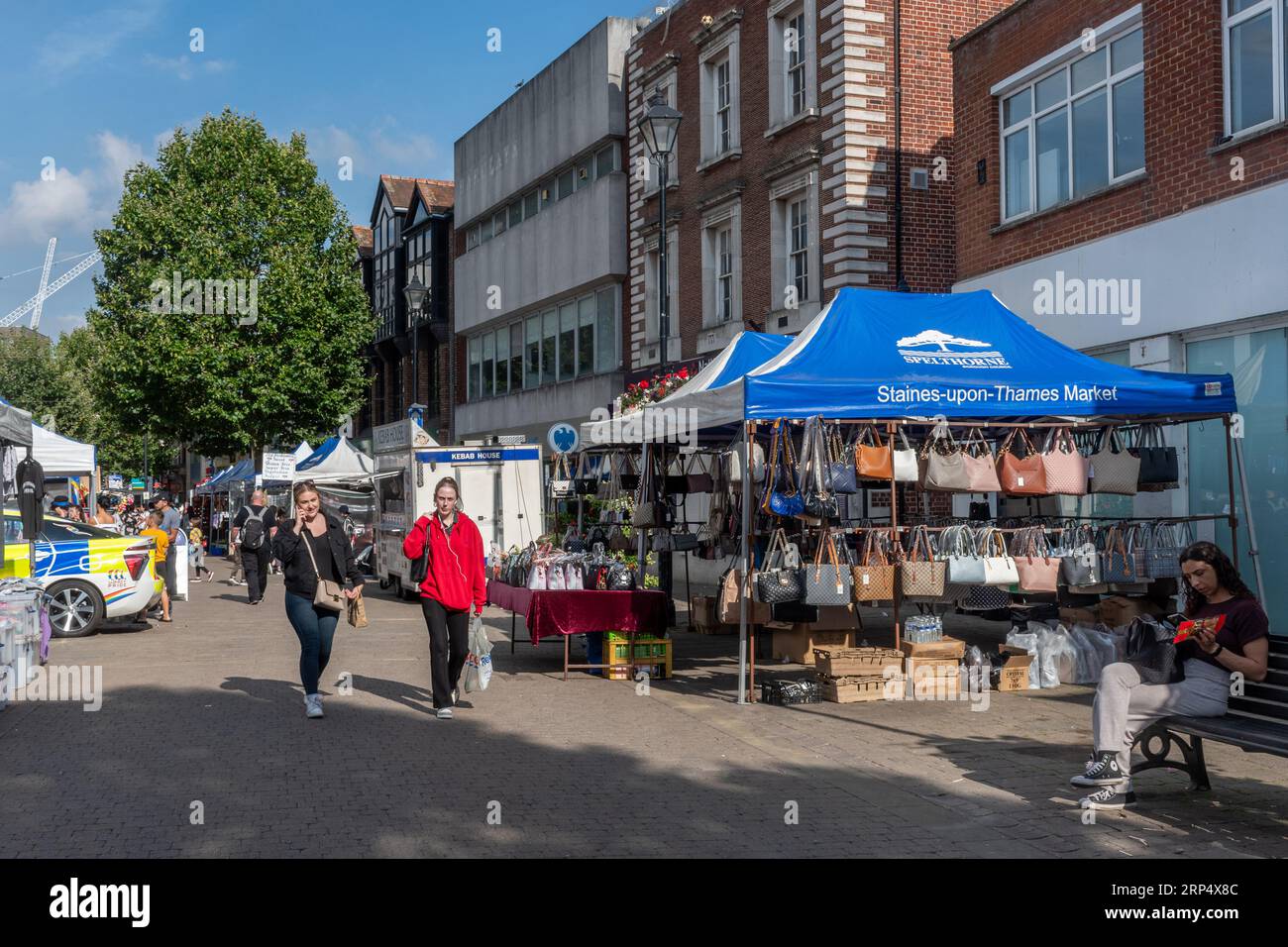 Mercato all'aperto nel centro di Staines-upon-Thames, Surrey, Inghilterra, Regno Unito, con negozi di gente Foto Stock