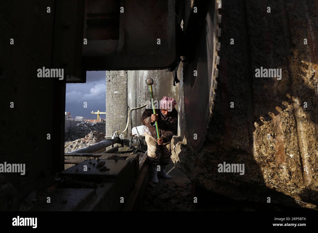 (181207) - CAIRO, 7 dicembre 2018 - Un uomo lavora in una fabbrica di marmo e granito al Cairo, Egitto, il 6 dicembre 2018. A Shaq al-Thu Ban un vasto cluster industriale di marmo e granito vicino alla capitale egiziana il distretto di Maadi del Cairo, circa 40 fabbriche di granito cooperativi cinesi ed egiziani e 30 fabbriche di marmo hanno contribuito in modo significativo a promuovere l'industria nel paese arabo più popoloso. ) La foto è accompagnata dall'articolo intitolato Feature: I macchinari cinesi potenziano l'industria del marmo e del granito in Egitto attraverso una proficua collaborazione. EGITTO-CAIRO-MACCHINARIO CINESE-MARMO E GRANITO GRAPPOLO INDUSTRIALE A Foto Stock