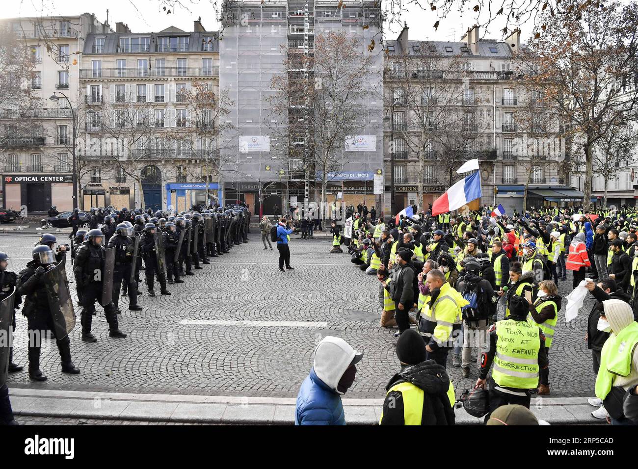 (181208) -- PARIGI, 8 dicembre 2018 -- i manifestanti gilet gialli affrontano la polizia vicino all'Arco di Trionfo a Parigi, Francia, l'8 dicembre 2018. La polizia antisommossa ha sparato gas lacrimogeni e cannoni ad acqua ai manifestanti Yellow Vests che marciano a Parigi sabato nel quarto week-end, nonostante la serie di concessioni del presidente Emmanuel Macron. ) (yy) FRANCIA-PARIGI- GILET GIALLI -PROTESTA ChenxYichen PUBLICATIONxNOTxINxCHN Foto Stock