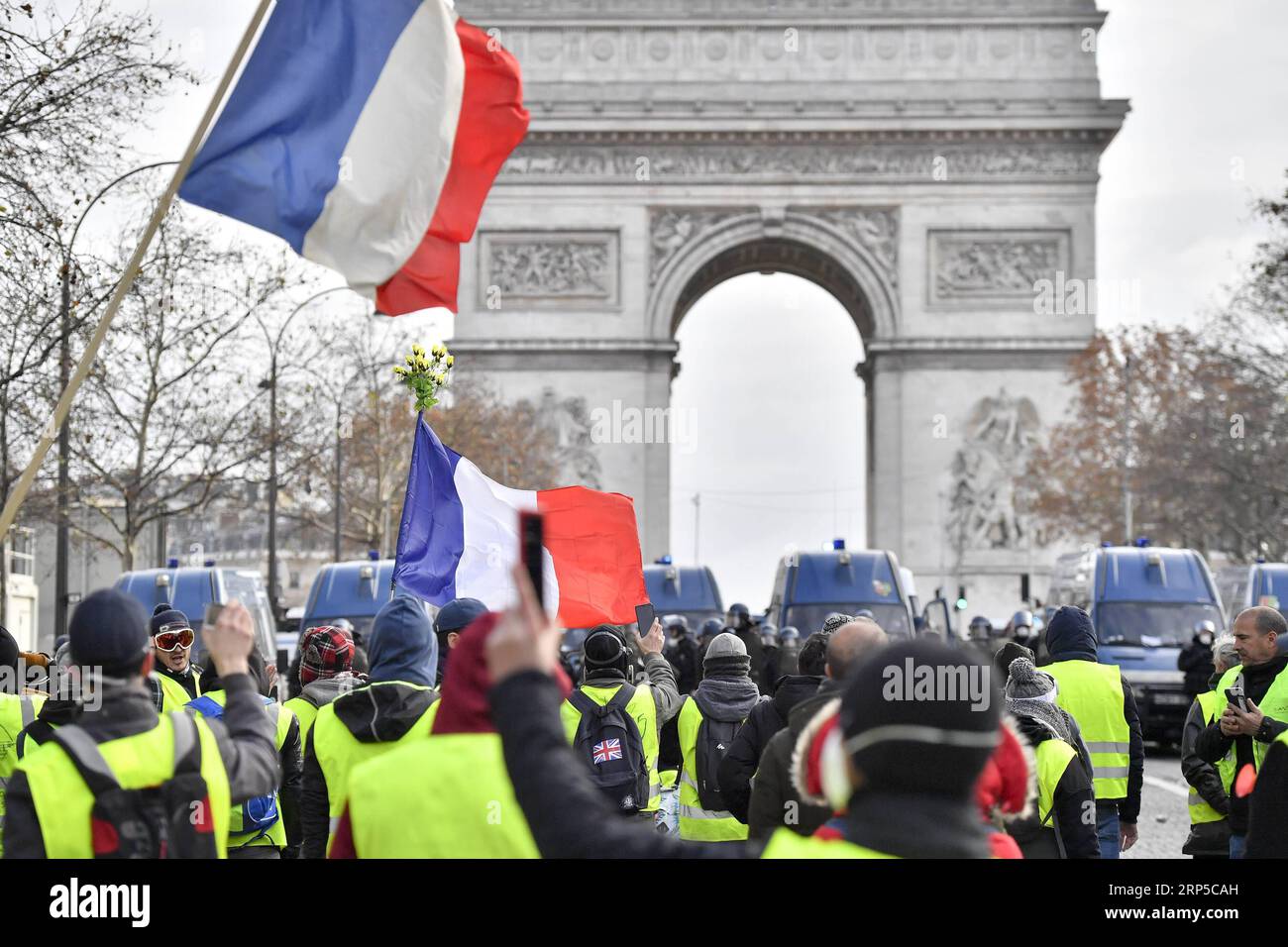 (181208) -- PARIGI, 8 dicembre 2018 -- i manifestanti gilet gialli affrontano la polizia vicino all'Arco di Trionfo a Parigi, Francia, l'8 dicembre 2018. La polizia antisommossa ha sparato gas lacrimogeni e cannoni ad acqua ai manifestanti Yellow Vests che marciano a Parigi sabato nel quarto week-end, nonostante la serie di concessioni del presidente Emmanuel Macron. ) (yy) FRANCIA-PARIGI- GILET GIALLI -PROTESTA ChenxYichen PUBLICATIONxNOTxINxCHN Foto Stock