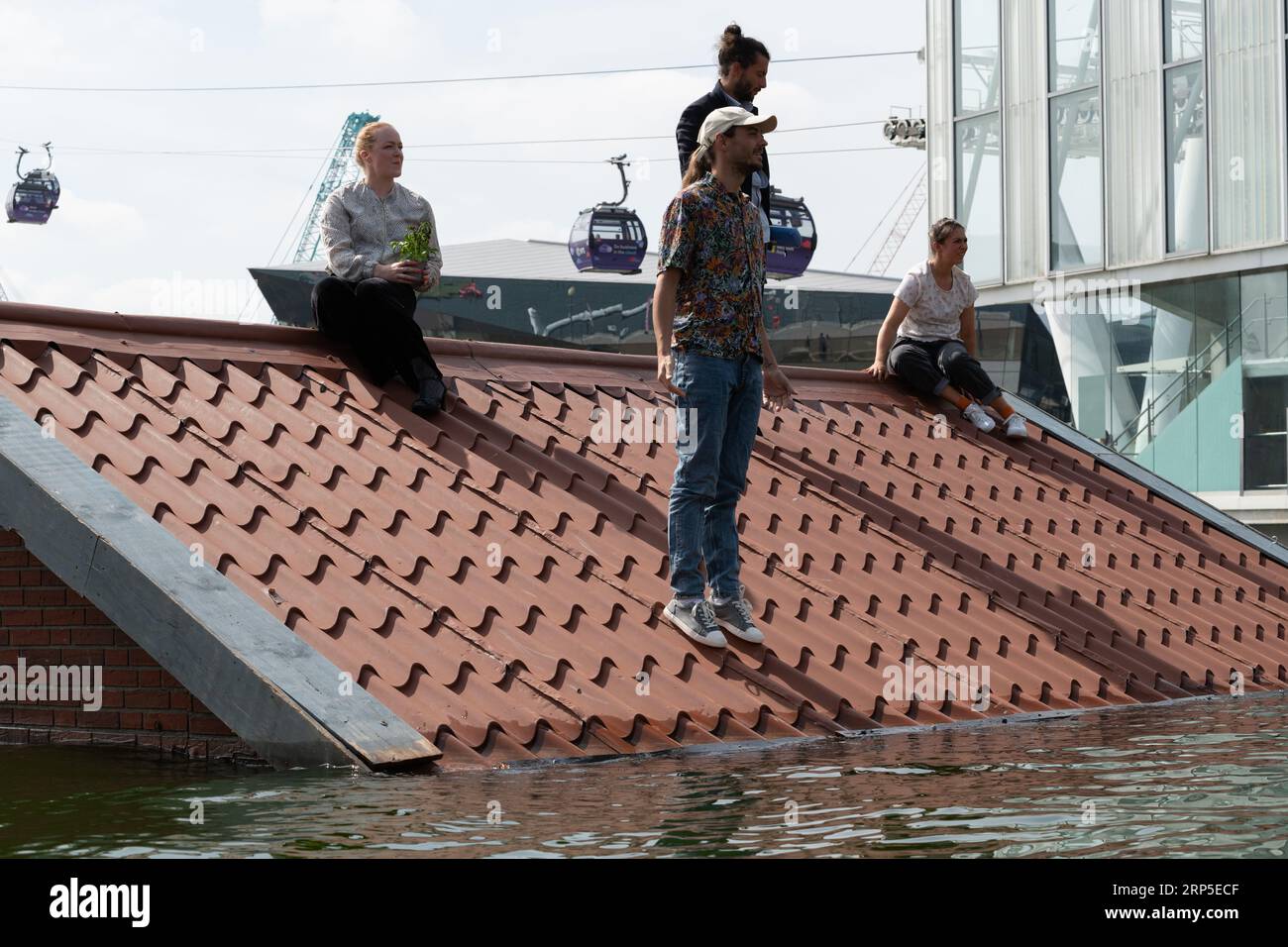 Londra, Regno Unito. 3 settembre 2023. La compagnia teatrale olandese Vloeistof esegue "Sliding Slope", in cui quattro persone lottano per sopravvivere sul tetto di una casa sommersa, come parte del Greenwich + Docklands International Festival. Il pezzo è stato ispirato dal diluvio del Mare del Nord del 1953, dove le alte maree e le tempeste hanno ucciso oltre 2.500 persone in Olanda e nel Regno Unito, e dalla minaccia attuale e futura del cambiamento climatico e dell'innalzamento del livello del mare. Crediti: Ron Fassbender/Alamy Live News Foto Stock