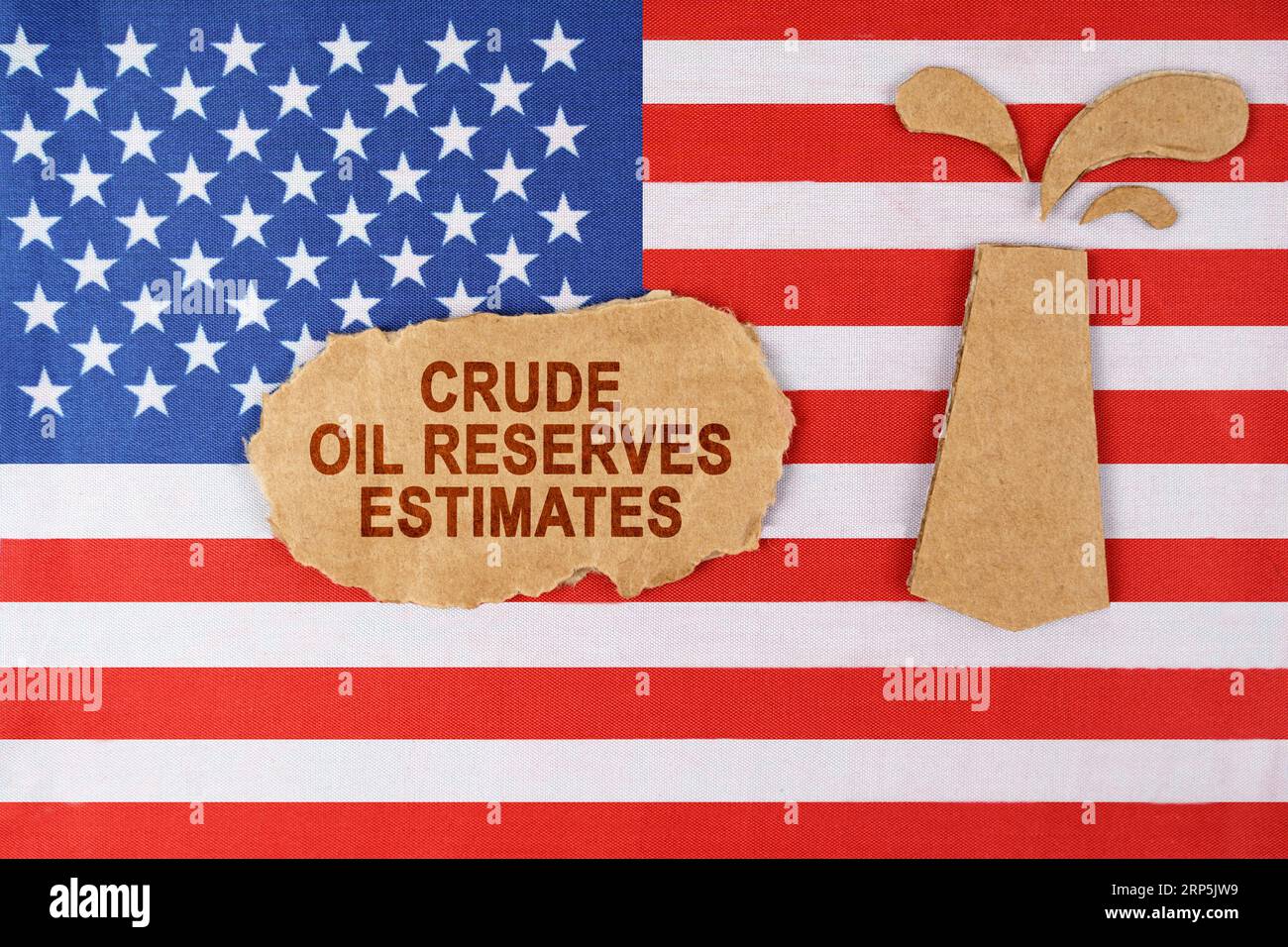 Sulla bandiera degli Stati Uniti c'è una piattaforma petrolifera tagliata fuori dal cartone e un cartello con l'iscrizione - stime delle riserve di petrolio greggio. Foto Stock