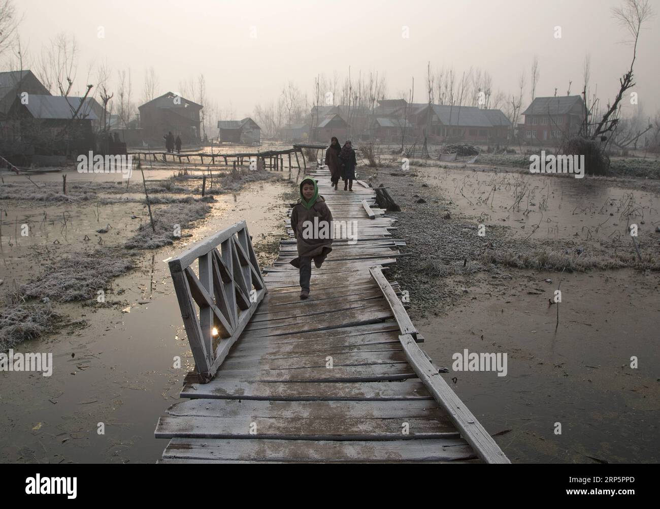 (181221) -- SRINAGAR, 21 dicembre 2018 -- i bambini del Kashmir camminano su una passerella coperta di gelo all'interno del lago dal in una fredda mattinata nella città di Srinagar, la capitale estiva del Kashmir controllato dagli indiani, 21 dicembre 2018. ) KASHMIR-SRINAGAR-FREDDO JavedxDar PUBLICATIONxNOTxINxCHN Foto Stock