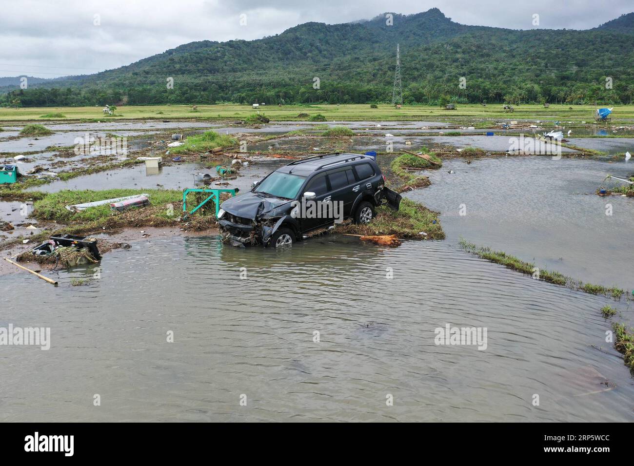 (181224) -- BANTEN, 24 dicembre 2018 (Xinhua) -- Un'auto è danneggiata dallo tsunami in un terreno agricolo nella provincia di Banten, in Indonesia, 24 dicembre 2018. Lunedì l'agenzia indonesiana per le catastrofi ha riportato il bilancio delle vittime dello tsunami innescato da un'eruzione vulcanica a 373 con altri 1.459 feriti, lunedì un portavoce dell'agenzia ha detto a Xinhua. (Xinhua/Du Yu) INDONESIA-BANTEN-TSUNAMI-AFTERMATH PUBLICATIONxNOTxINxCHN Foto Stock