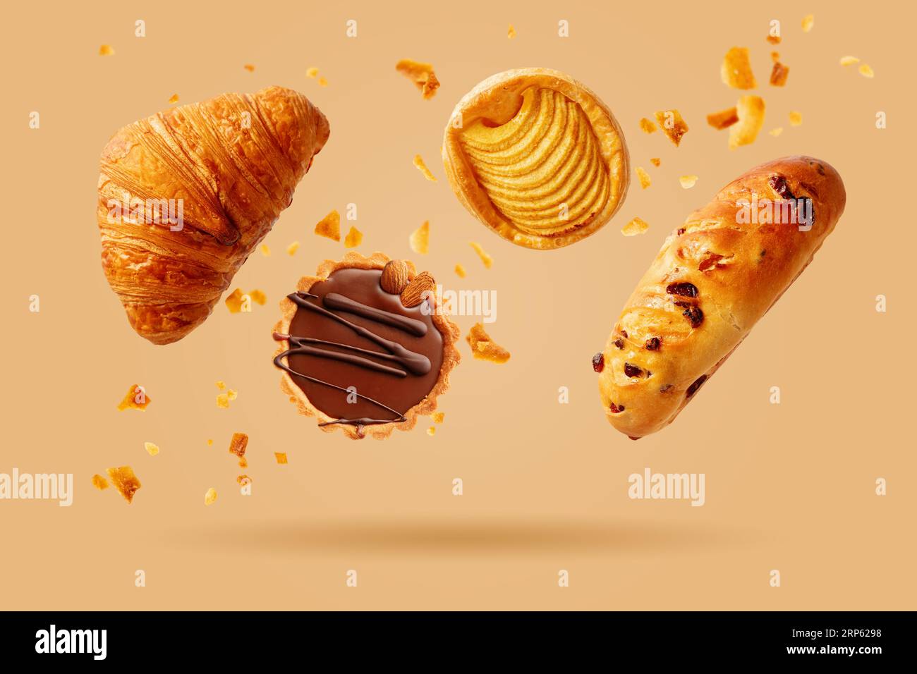 Croissant appena sfornati e dolci che volano nell'aria. Dolce dolce. Prodotti da forno. Foto Stock