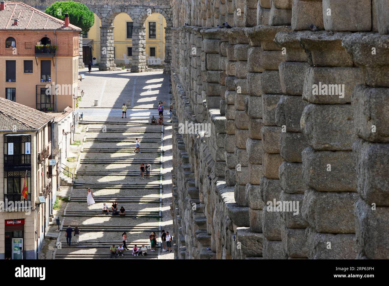 Vista dell'acquedotto romano di Segovia, con piccole figure umane per proporzione Foto Stock