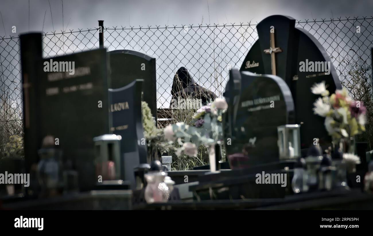 Sembra che Grim Reaper stia aspettando qualcuno al cimitero. Foto spaventose di Halloween. Foto Stock