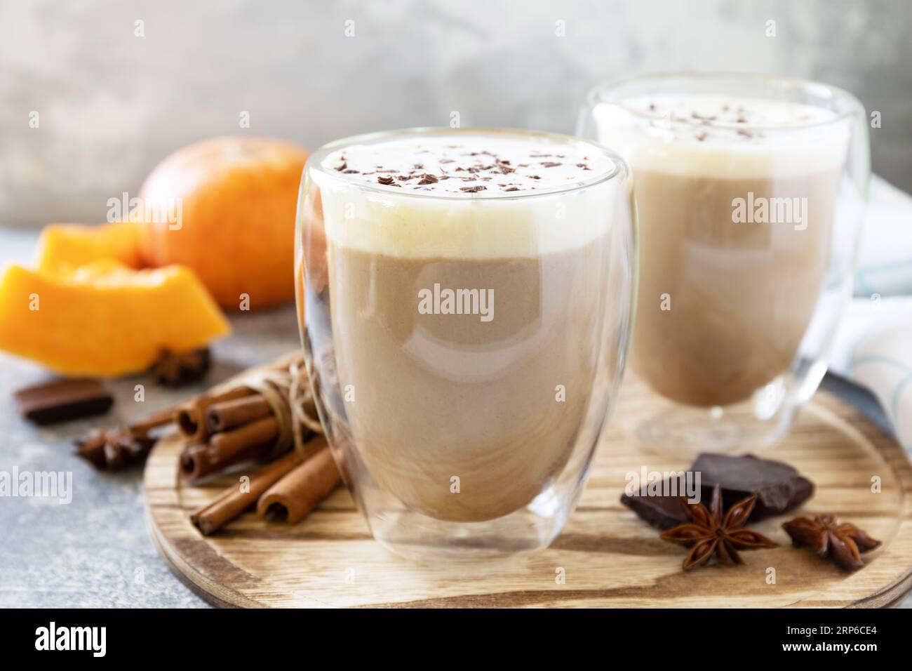 Concetto autunnale stagionale con bevanda calda. Caffè con latte e spezie di zucca su uno sfondo di pietra. Foto Stock