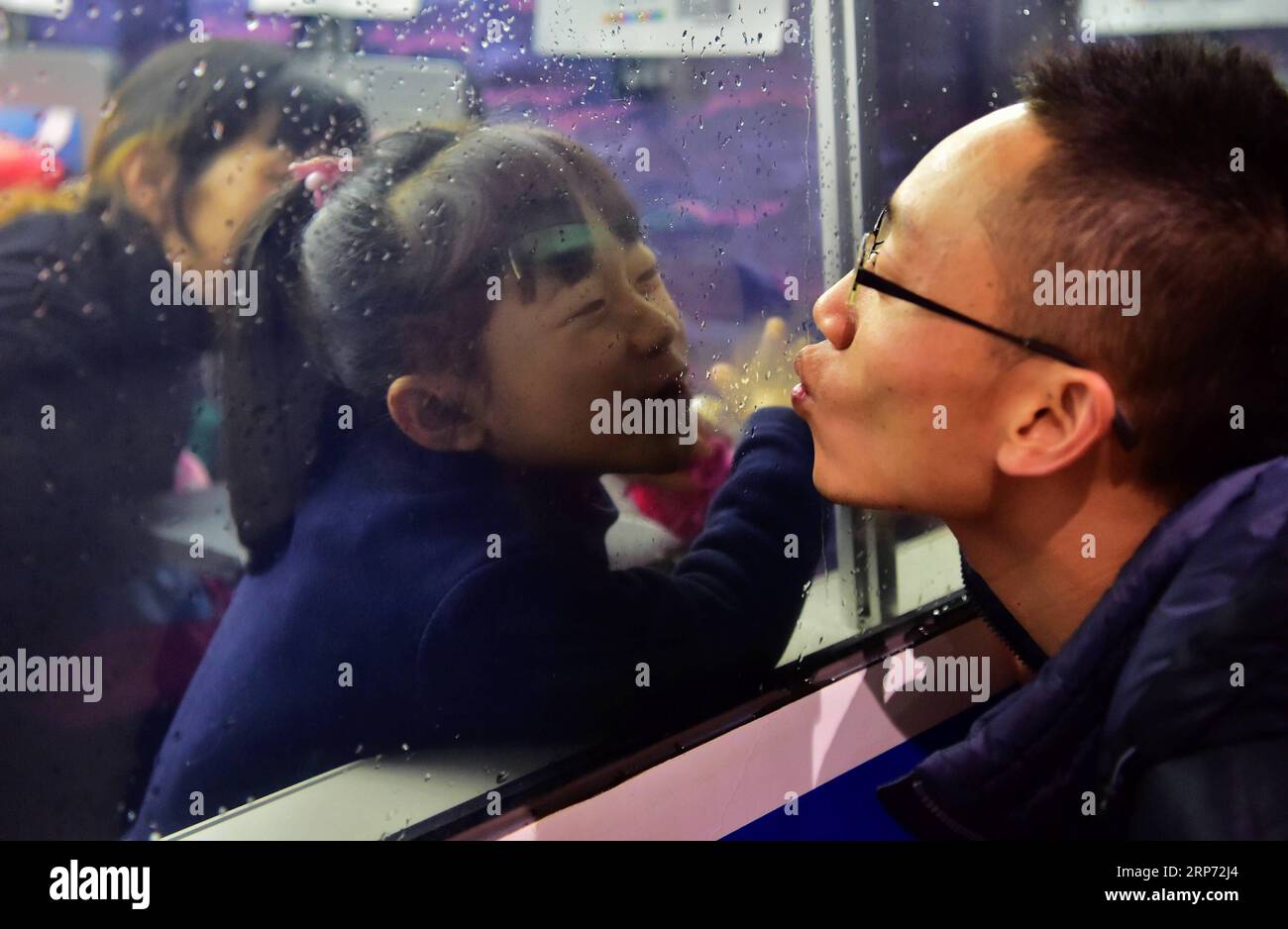 (190125) --PECHINO, 25 gennaio 2019 -- la foto del file scattata il 13 gennaio 2017 mostra il lavoratore migrante Luo Jiang (R) che bacia sua figlia attraverso la finestra di un treno alla stazione ferroviaria di Fuzhou a Fuzhou, capitale della provincia del Fujian della Cina sudorientale. Poiché la riunione con la famiglia durante il Capodanno lunare è una tradizione di lunga data in Cina, la gente si imbarca per tornare a casa prima del Festival di Primavera, che cade il 5 febbraio di quest'anno. La corsa di 40 giorni al Festival di Primavera del 2019 è iniziata il 21 gennaio, con 3 miliardi di viaggi previsti. Ecco alcuni momenti toccanti lungo il ritorno di bou Foto Stock
