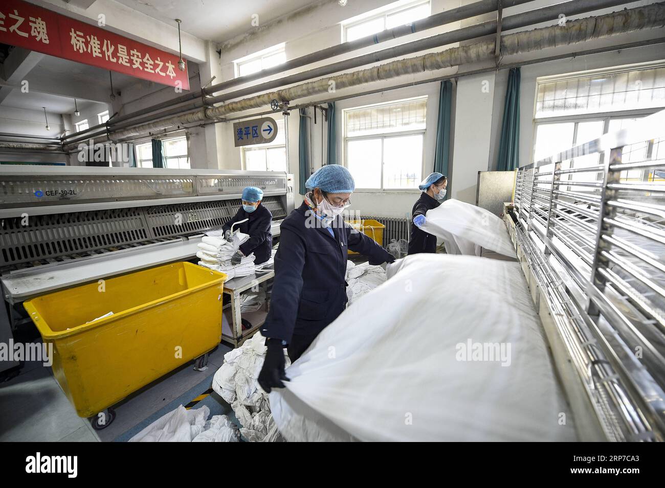 (190203) -- YINCHUAN, 3 febbraio 2019 (Xinhua) -- i membri del personale stirano i letti dei treni lavati in un centro di servizi di lavanderia ferroviaria a Yinchuan, regione autonoma Ningxia Hui della Cina nord-occidentale, 1 febbraio 2019. Durante la stagione dei viaggi del Festival di Primavera Cinese, il personale del servizio di lavanderia presso la sezione passeggeri di Yinchuan dell'Amministrazione ferroviaria di Lanzhou sarà incaricato di pulire più di 80.000 pezzi, o circa 18 tonnellate, di lettiere del treno al giorno. In un centro lavanderia di 1.300 metri quadrati, i lavoratori lavano, asciugano, stirano, smistano e confezionano le lenzuola per i viaggi in treno in arrivo. (Xinhua/Feng Kaihua) CINA-NINGXIA Foto Stock