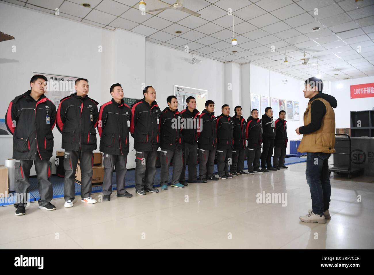 (190203) -- XI AN, 3 febbraio 2019 (Xinhua) -- Deliveryman Luo Feilong (3rd L) partecipa a un incontro in un centro di distribuzione a Xi An, capitale della provincia dello Shaanxi della Cina nord-occidentale, 3 febbraio 2019. Luo Feilong, un liberatore di 31 anni della provincia dello Shaanxi, consegna pacchi in una comunità di Xi An da quattro anni. Luo ha chiesto di essere in servizio durante la festa di Primavera di quest'anno, in modo che altri consegnatieri provenienti da fuori provincia possano tornare nella loro città natale per riunioni familiari. (Xinhua/Zhang Bowen) CHINA-XI AN-SPRING FESTIVAL-DELIVERYMAN (CN) PUBLICATIONxNOTxINxCHN Foto Stock