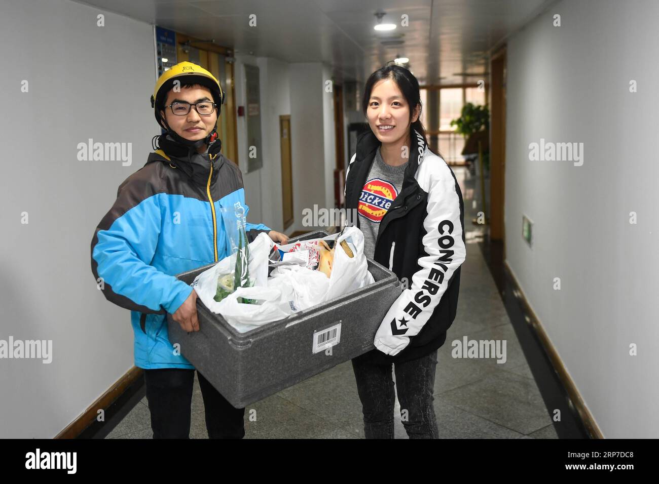 (190204) -- HANGZHOU, 4 febbraio 2019 (Xinhua) -- Zhou Xiaoyu,(R) prende ingredienti freschi per la cena di riunione di famiglia il capodanno cinese da un corriere a Hangzhou, nella provincia dello Zhejiang della Cina orientale, 3 febbraio 2019. (Xinhua/Huang Zongzhi) CHINA-HANGZHOU-LUNAR CAPODANNO (CN) PUBLICATIONxNOTxINxCHN Foto Stock