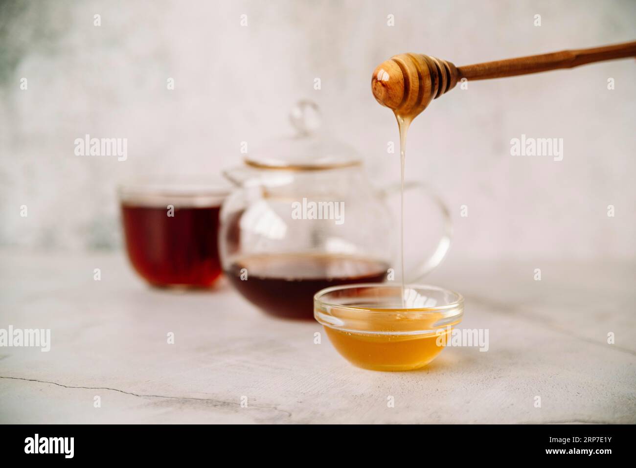 Vista frontale, sfondo sfocato con tè e miele Foto Stock