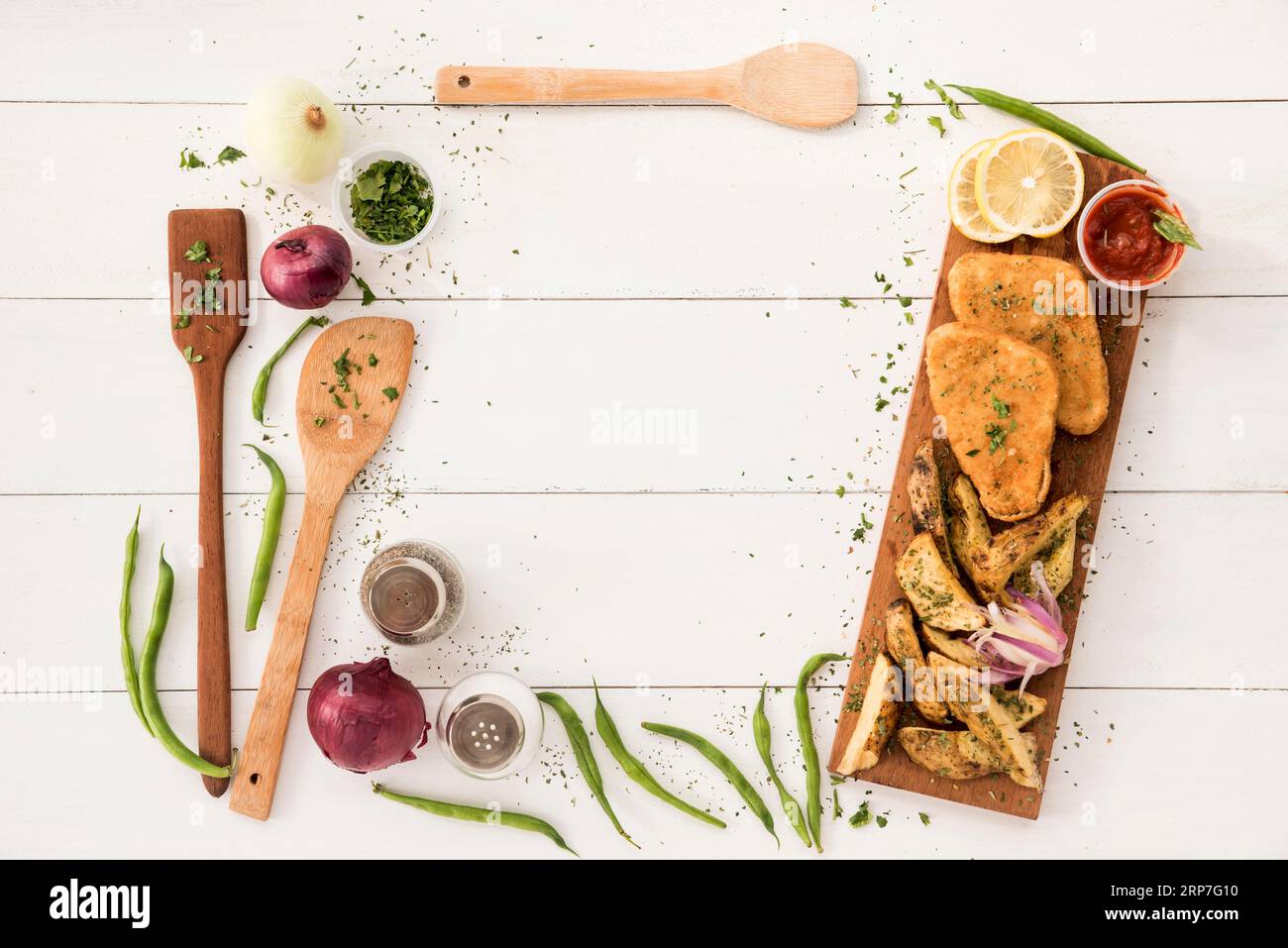 Disposizione dei bordi con utensili da cucina, tavolo in legno per pasti pronti Foto Stock