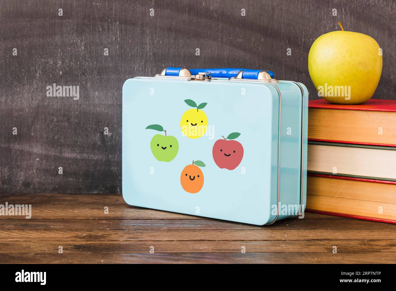Pranzo al box vicino a una pila di libri mela Foto Stock
