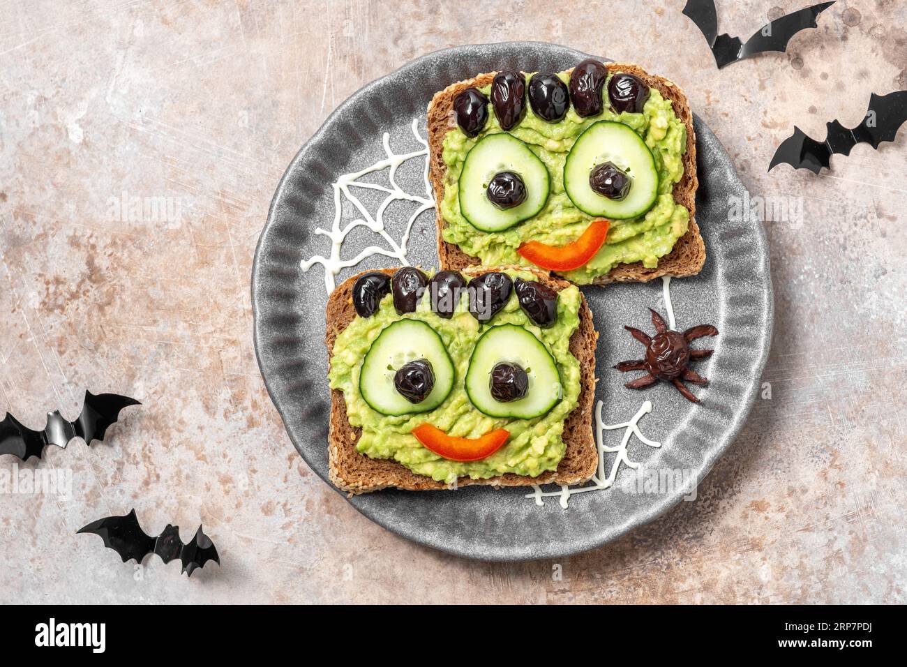 Brindisi con un mostro verde di avocado per Halloween Foto Stock