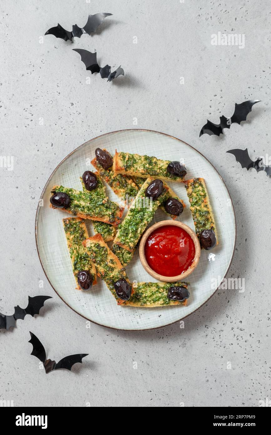 Cibo di Halloween. Pane tostato all'aglio con le dita della strega di Halloween con prezzemolo e aglio Foto Stock