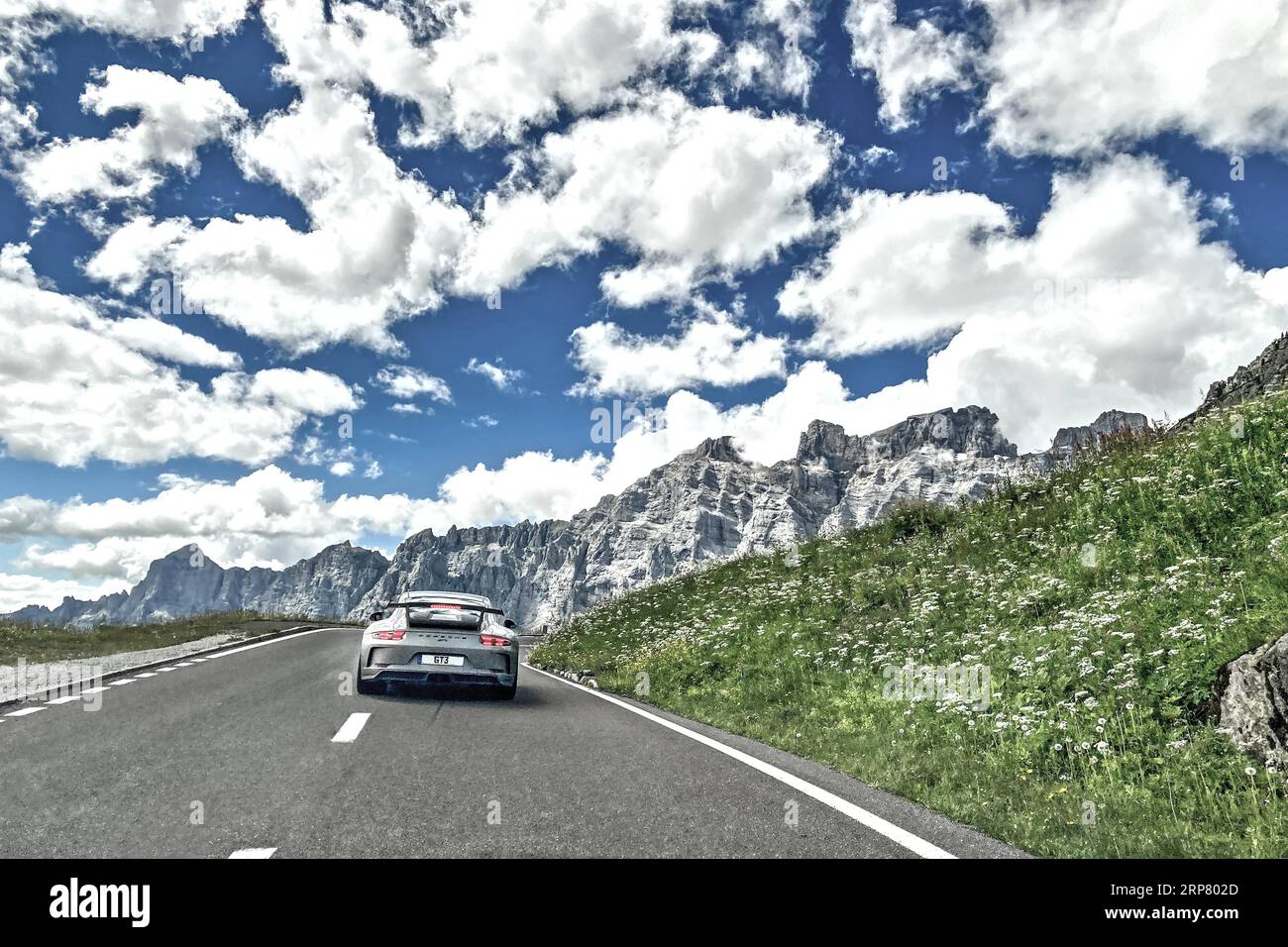 Foto con saturazione della gamma dinamica ridotta HDR di vista della Porsche 911 GT3 che guida su una strada di montagna sopra la linea degli alberi passo della strada passo alpino montagna Foto Stock