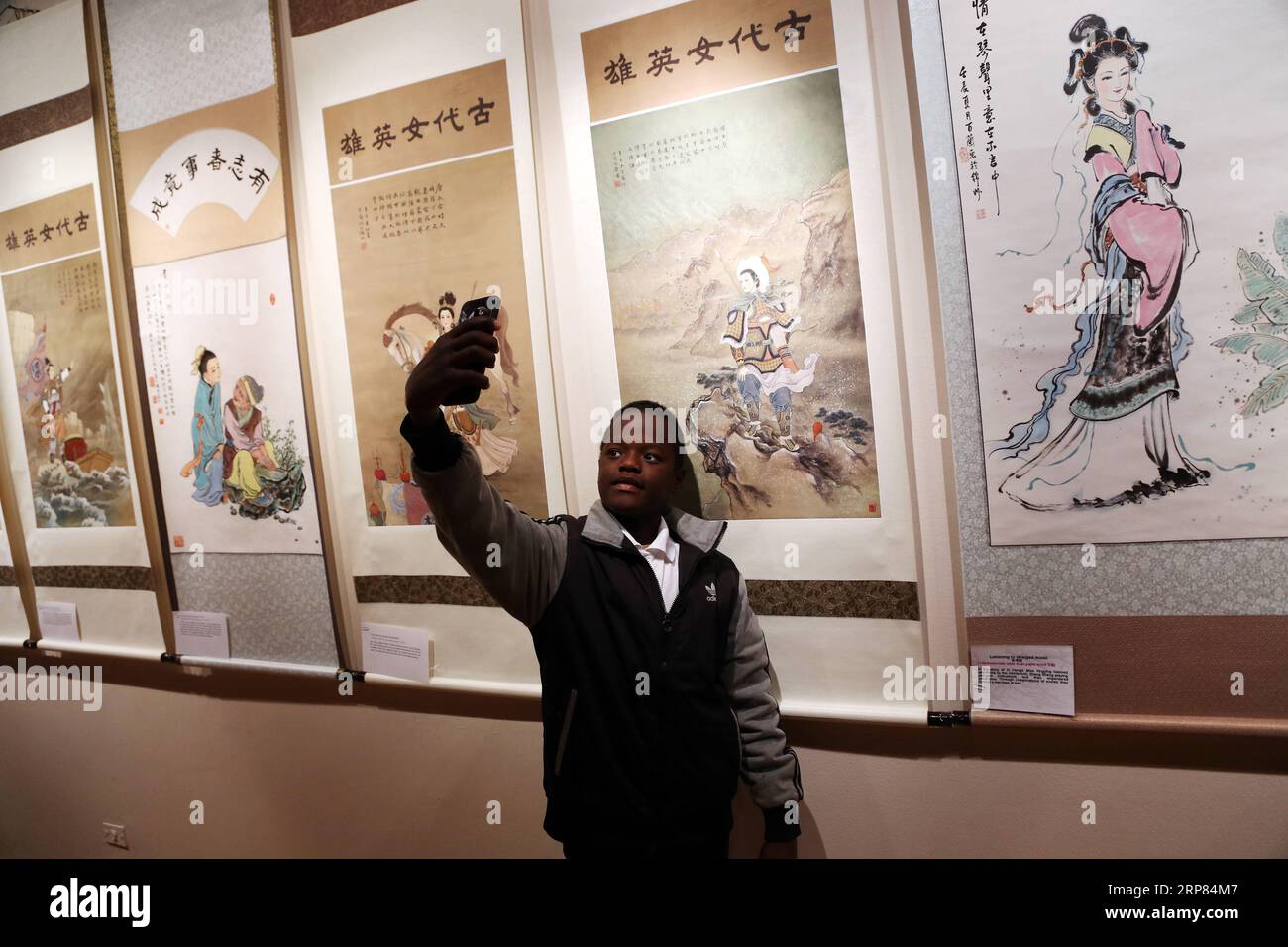 (190217) -- CAIRO, 17 febbraio 2019 -- Un uomo scatta selfie in una mostra al Cairo, Egitto, il 16 febbraio 2019. I dipinti della famosa pittrice cinese Qin Bailan hanno decorato una mostra internazionale nella capitale egiziana il Cairo. La mostra faceva parte della terza edizione dell'Awladna International Forum for Arts of the Gifted. Qin, i cui dipinti riguardano figure tradizionali, ha detto che ha promosso per la cultura cinese attraverso i suoi dipinti per 40 anni. Nonostante la sua disabilità, Qin non gli permise di definirla. Si è fatta un nome come uno dei migliori artisti della Cina. Foto Stock