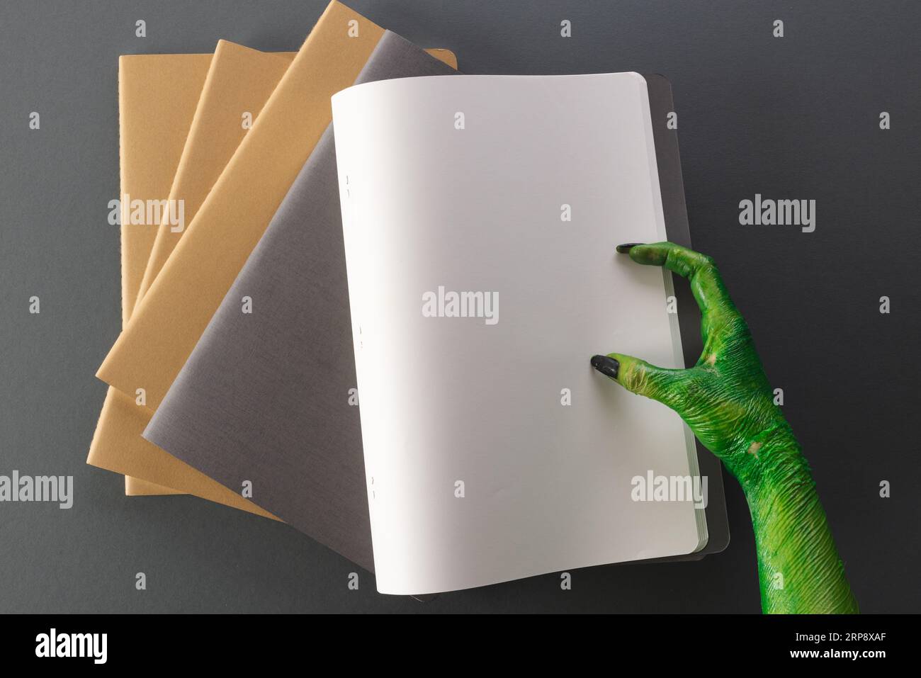 Quaderno con mano mostro verde con spazio per la copia su sfondo grigio Foto Stock