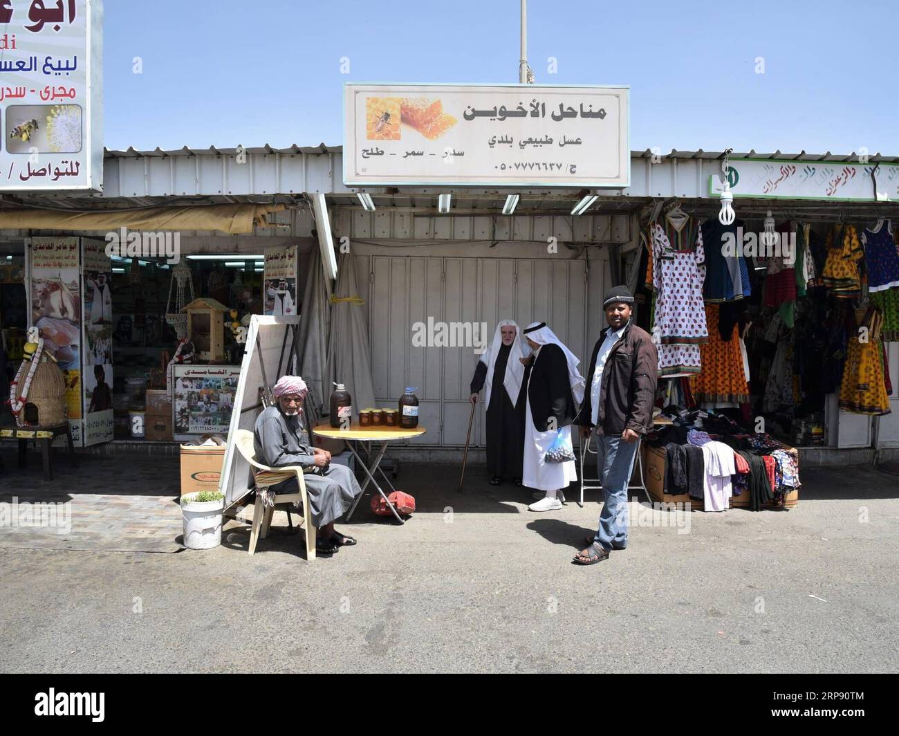 (190319) -- ABHA (ARABIA SAUDITA), 19 marzo 2019 (Xinhua) -- i commercianti di miele locali salutano i visitatori all'ingresso del mercato di Thulatha ad Abha, provincia di Asir, Arabia Saudita, il 19 marzo 2019. Thulatha, un famoso mercato tradizionale nella città di Abha, vende prodotti freschi e artigianato locale, come miele, datteri, gioielli beduini in oro e argento, abiti da donna ricamati e pugnali fatti localmente. Il mercato di Thulatha era aperto solo il martedì e ora è aperto sette giorni su sette, attirando molti acquirenti e visitatori. (Xinhua/tu Yifan) ARABIA SAUDITA-ABHA-MARKET PUBLICATIONxNOTxINxCHN Foto Stock