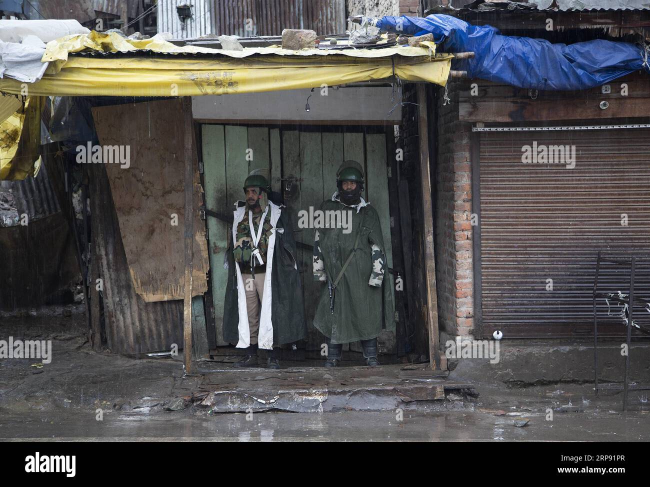 (190320) -- SRINAGAR, 20 marzo 2019 (Xinhua) -- i soldati paramilitari indiani stanno di guardia davanti a un negozio chiuso durante il blocco della sicurezza a Srinagar, la capitale estiva del Kashmir controllato dagli indiani, 20 marzo 2019. La vita normale nelle aree a maggioranza musulmana del Kashmir restive controllato dall'India mercoledì è rimasta colpita a causa di uno sciopero sulla morte custode di un insegnante di scuola. L'appello allo sciopero è stato dato dai gruppi separatisti della regione sotto la bandiera della Joint Resistance Leadership (JRL). (Xinhua/Javed Dar) KASHMIR-SRINAGAR-LOCKDOWN PUBLICATIONxNOTxINxCHN Foto Stock