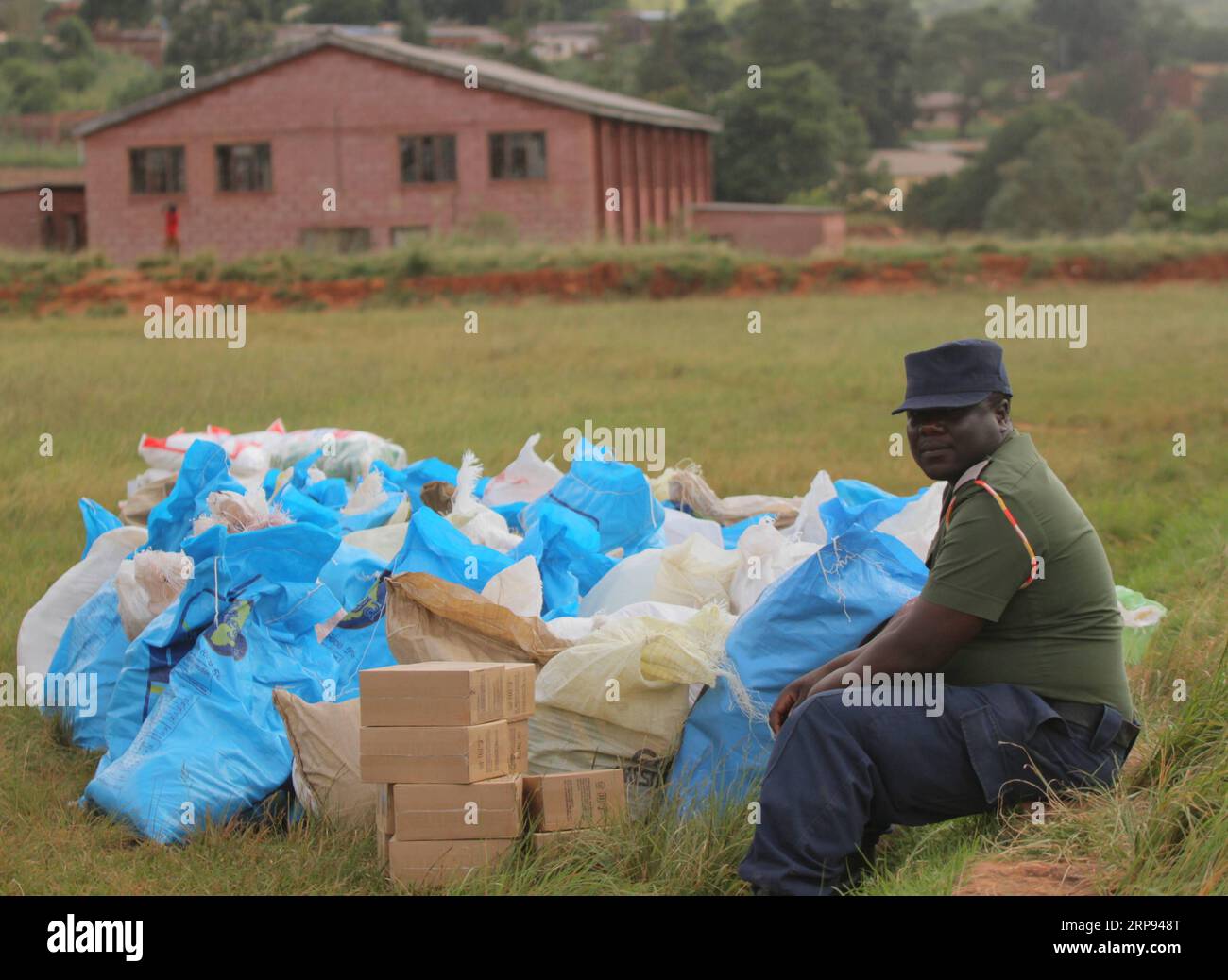 Simbabwe, Schäden nach Zyklon Idai (190322) -- CHIMANIMANI (ZIMBABWE), 22 marzo 2019 -- Una guardia orologi donò cibo a Chimanimani, provincia di Manicaland, Zimbabwe, 22 marzo 2019. Giovedì il Presidente dello Zimbabwe Emmerson Mnangagwa ha dichiarato due giorni di lutto nazionale a seguito del devastante ciclone Idai, che ha ucciso 139 persone e lasciato una scia di distruzione nelle parti orientali e meridionali del paese. Mentre gli sforzi di salvataggio e ricerca continuano, le donazioni di aiuti alle vittime continuano ad essere versate da persone locali, aziende, governi regionali e aiuti internazionali Foto Stock