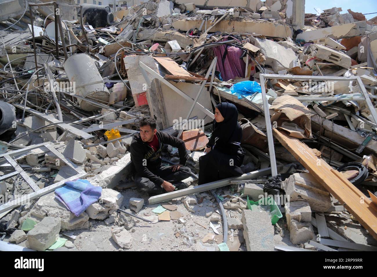 (190329) -- GAZA, 29 marzo 2019 -- Walid al-Shawa palestinese e la sua fidanzata Naila al-Jalis siedono sulle macerie della loro casa che è stata abbattuta in un raid israeliano all'inizio di questa settimana, nella città di Gaza, il 28 marzo 2019. Nella Striscia di Gaza palestinese, i piani di matrimonio di una coppia palestinese sono stati distrutti dopo che un attacco aereo israeliano ha distrutto l'edificio residenziale che ospitava il loro futuro nido. PER ANDARE CON la caratteristica: Attacchi aerei israeliani uccidono i piani nuziali della coppia palestinese a Gaza ) MIDEAST-GAZA-PALESTINA COPPIA-DISTRUTTO CASA Stringer PUBLICATIONxNOTxINxCHN Foto Stock