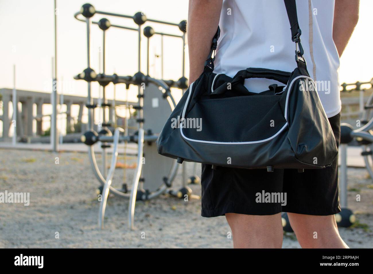 Sezione centrale di un giovane che va al centro sportivo all'aperto con la sua borsa da atletica. Copia spazio Foto Stock