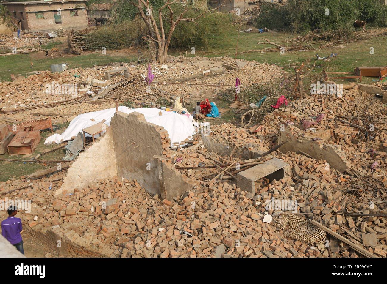 (190402) -- BARA, 2 aprile 2019 -- le persone riposano sulle macerie di case danneggiate da una tempesta massiccia nel villaggio di Purainiya, distretto di Bara in Nepal, 2 aprile 2019. Almeno 25 persone sono rimaste uccise e 400 altre ferite quando una tempesta ha devastato i villaggi in due distretti del Nepal domenica sera, ha confermato il primo ministro nepalese K.P. Sharma oli. ) NEPAL-STORM-AFTERMATH sunilxsharma PUBLICATIONxNOTxINxCHN Foto Stock