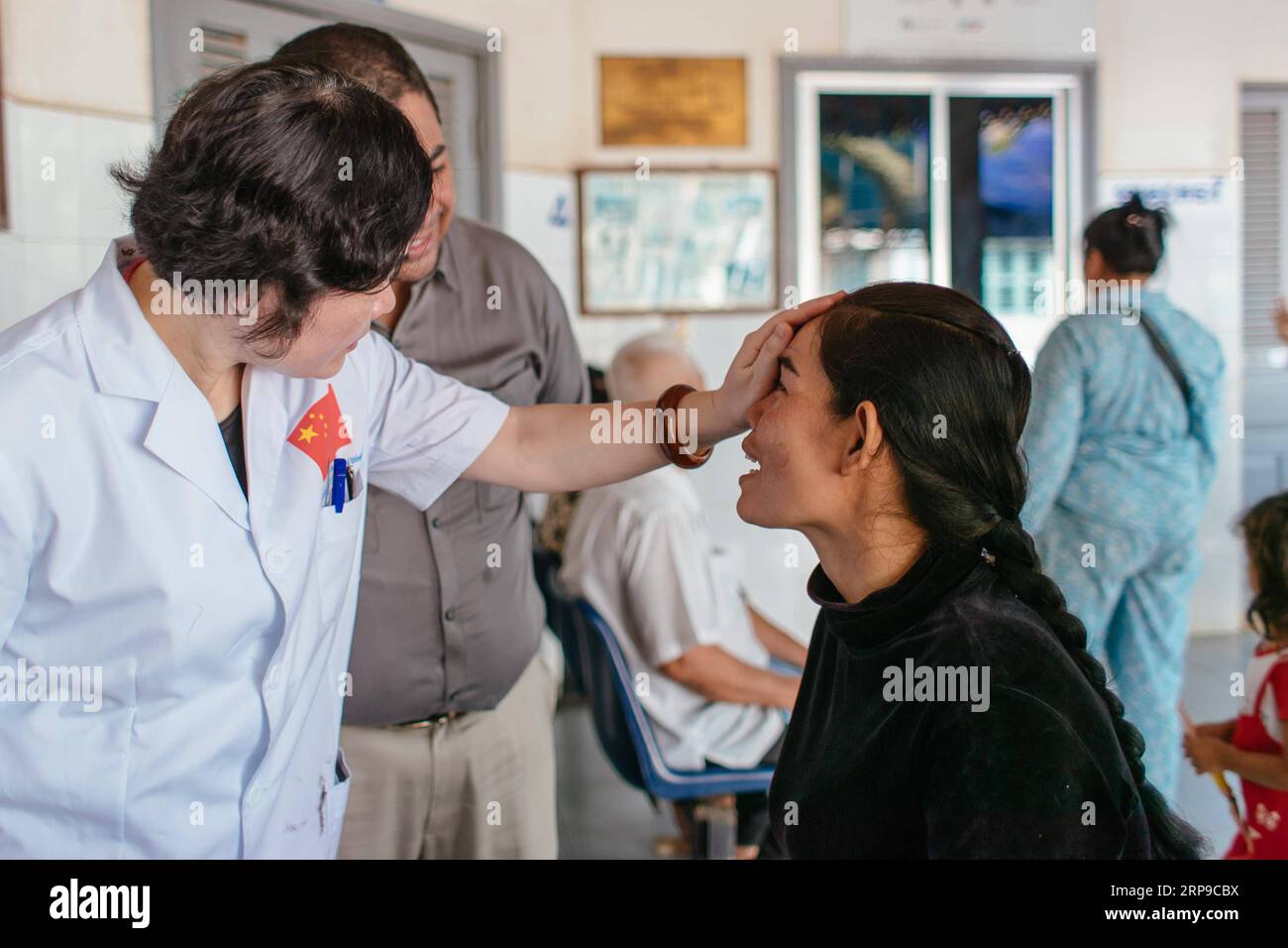 (190402) - PHNOM PENH, 2 aprile 2019 (Xinhua) - Dottor Liang Hao (L) del primo ospedale affiliato della Guangxi Medical University parla con Sum Meyle dopo un'operazione di cataratta presso l'ospedale provinciale di Kampong Cham a Kampong Cham, Cambogia, 16 marzo 2019. Sum Meyle, 36 anni, è una madre single con cinque figli. Per contribuire a migliorare le loro condizioni finanziarie, due delle figlie di Meyle stanno ora lavorando nella capitale Phnom Penh, mentre due dei suoi figli vivono in una casa di cura per bambini. Meyle ora vive in una baraccopoli affittata con la figlia più giovane. Meyle aveva sofferto di cataratta dopo di lei Foto Stock