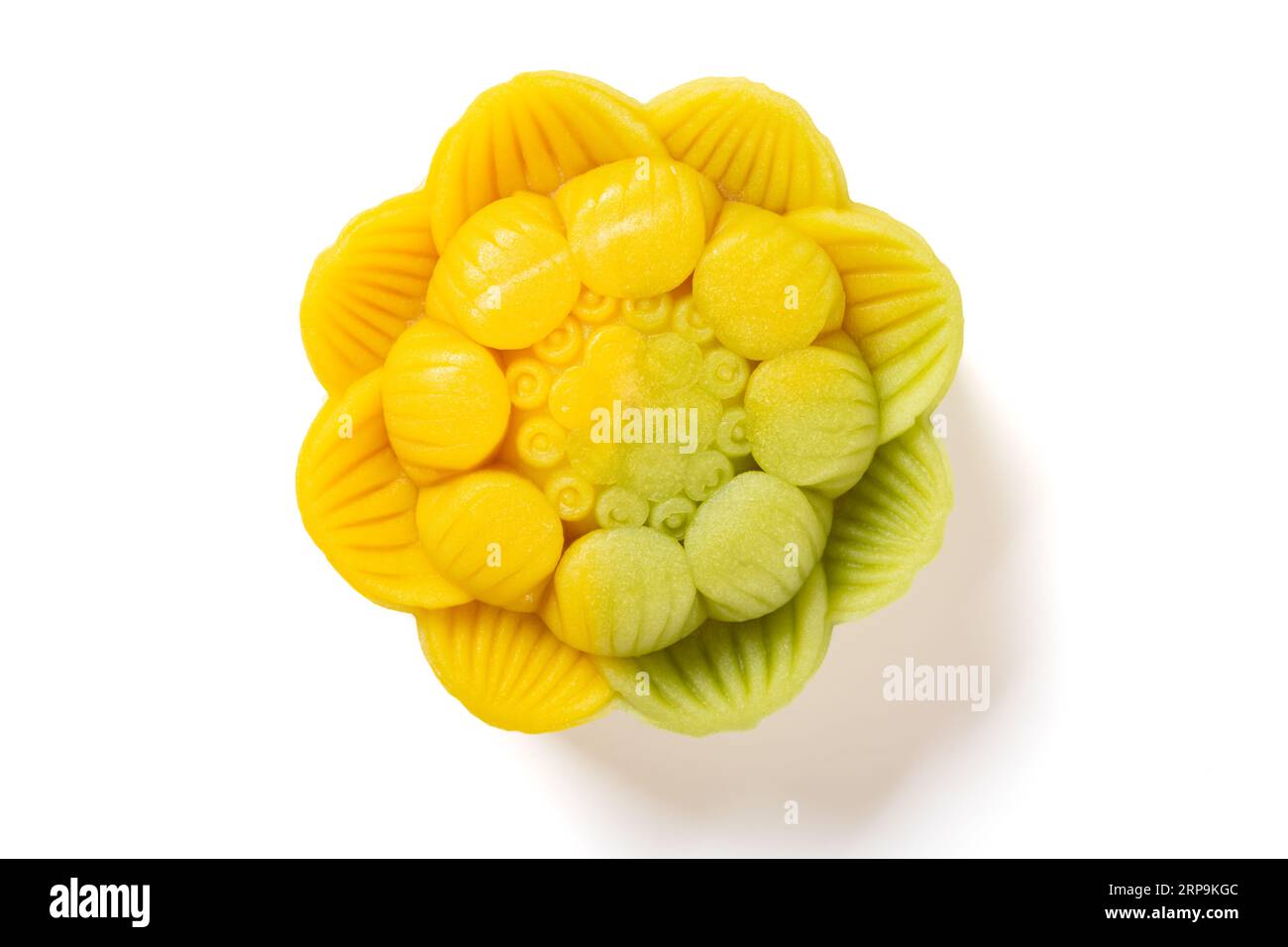 vista dall'alto elegante e bellissima torta luna dai colori giallo e verde a forma di fiore su sfondo bianco Foto Stock