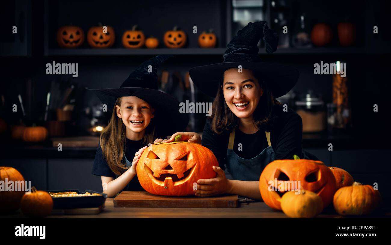 Madre e sua figlia si divertono a casa. Happy Family in preparazione per Halloween. Mamma e bambino cucinano piatti festosi in cucina. Foto Stock