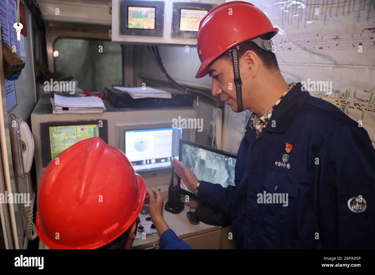 (190430) -- XI AN, 30 aprile 2019 (Xinhua) -- Liang Xijun (R), ingegnere senior del First Engineering Bureau of China Railway Group Limited, comunica con un collega in un cantiere a Xi An, nella provincia dello Shaanxi della Cina nord-occidentale, il 29 aprile 2019. Negli ultimi 13 anni, Liang Xijun si è evoluta da una nuova recluta a un esperto in termini di costruzione della metropolitana attraverso un apprendimento e una pratica coerenti. Ha partecipato ai lavori di costruzione di 5 linee della metropolitana e ha ricevuto la National Labor Medal e la 4 maggio Medal of Shaanxi Province. Sotto la sua guida, le officine portano il suo nome Foto Stock