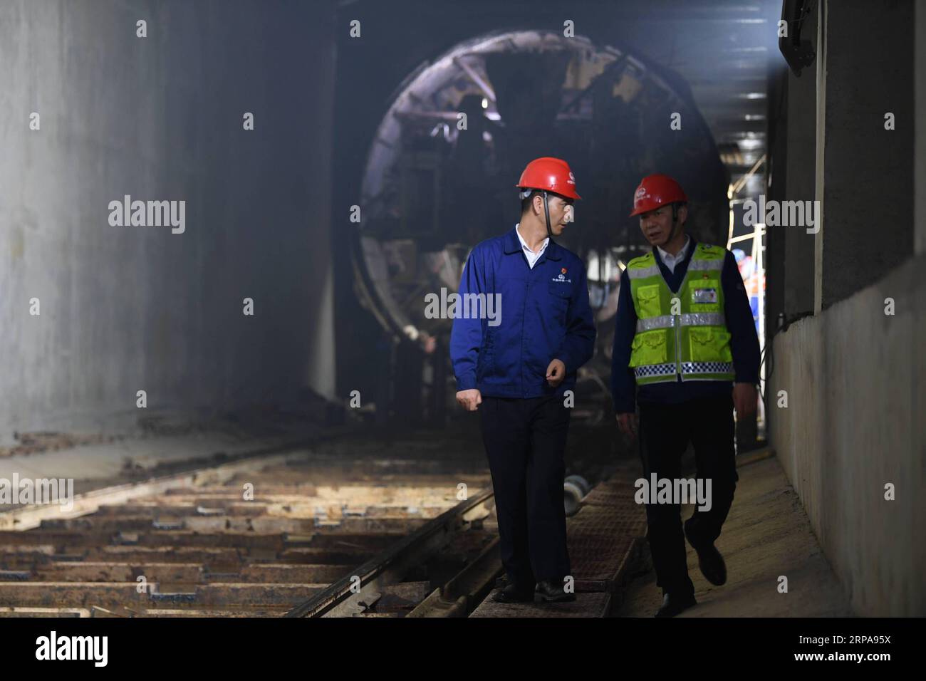 (190430) -- XI AN, 30 aprile 2019 (Xinhua) -- Liang Xijun (L), ingegnere senior del First Engineering Bureau of China Railway Group Limited, comunica con un collega in un cantiere a Xi An, nella provincia dello Shaanxi della Cina nord-occidentale, il 29 aprile 2019. Negli ultimi 13 anni, Liang Xijun si è evoluta da una nuova recluta a un esperto in termini di costruzione della metropolitana attraverso un apprendimento e una pratica coerenti. Ha partecipato ai lavori di costruzione di 5 linee della metropolitana e ha ricevuto la National Labor Medal e la 4 maggio Medal of Shaanxi Province. Sotto la sua guida, le officine portano il suo nome Foto Stock