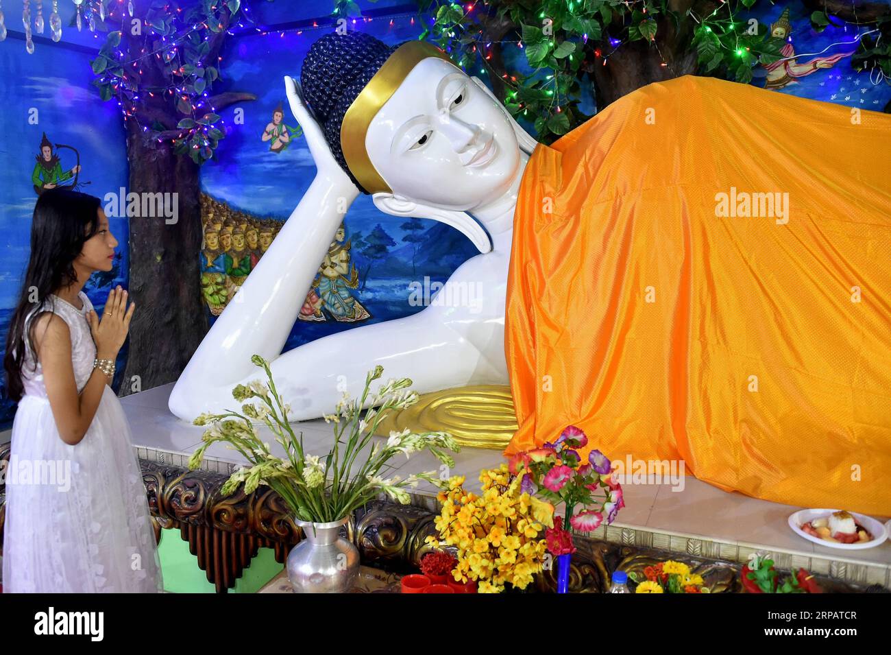 (190518) -- DACCA, 18 maggio 2019 () -- Una ragazza prega davanti a una grande statua di Buddha durante la celebrazione del Buddha Purnima a Dacca, Bangladesh, il 18 maggio 2019. Sabato i buddisti in Bangladesh hanno celebrato il Buddha Purnima , che segna la nascita, l'illuminazione e la morte di Gautama Buddha. () BANGLADESH-DHAKA-BUDDHA PURNIMA Xinhua PUBLICATIONxNOTxINxCHN Foto Stock