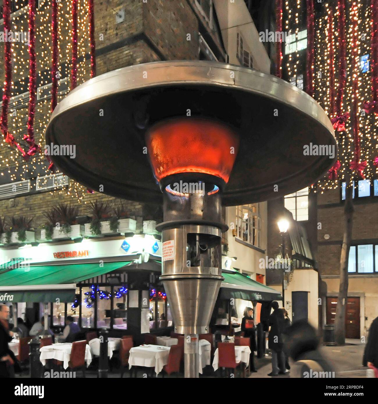 Primo piano dell'elemento riscaldante per ambienti esterni Calor gas accanto ai tavoli dei ristoranti a Natale a St Christophers Place West End Londra Inghilterra Regno Unito Foto Stock